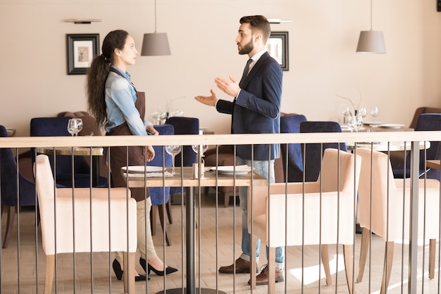 Gérant de restaurant confiant expliquant les tâches à la serveuse