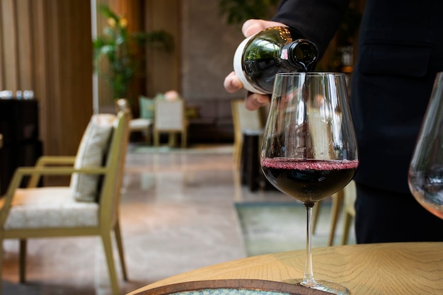 Gérant de restaurant thaïlandais et serveur versant du vin dans un verre pour les boissons des clients servis et goûter savoureux avant de manger le plat principal de la cuisine alimentaire dans la salle à manger du café du restaurant à Bangkok en Thaïlande