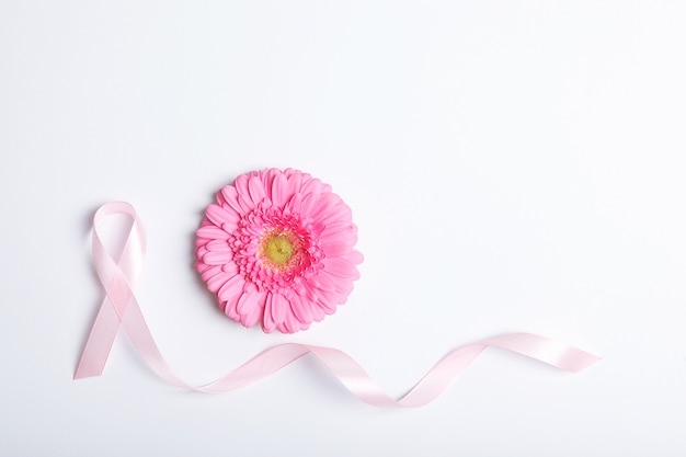 Gerbera de ruban rose et stéthoscope sur une vue de dessus de fond coloré