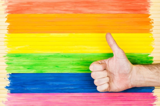 Geste de défilé gay de personnes et concept homosexuel montrant des symboles sur le fond de la bande de drapeau arc-en-ciel