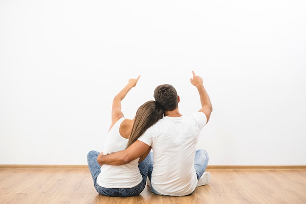 Le geste du couple assis sur le fond du mur vide