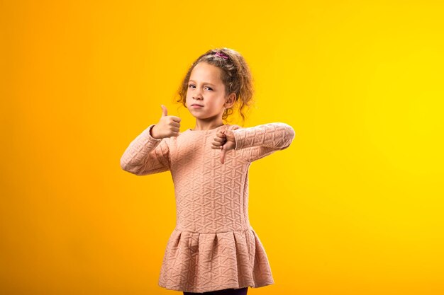 Geste de l'enfant montrant le pouce haut et le pouce bas Concept d'émotions positives et négatives