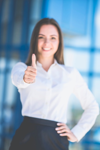 Le geste de la femme heureuse sur le fond du centre d'affaires