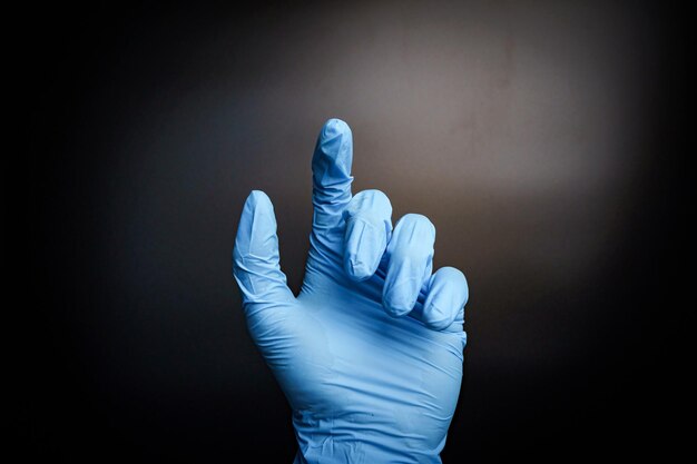 Geste de gant chirurgical à la main par main libre isolé fond noir prise de vue moyenne