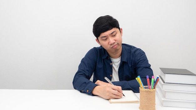 Geste de l'homme ennuyé de travailler et de lire un livre sur l'espace de copie de table