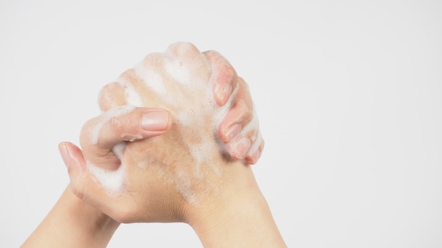Geste de lavage des mains avec du savon moussant pour les mains sur fond blanc.