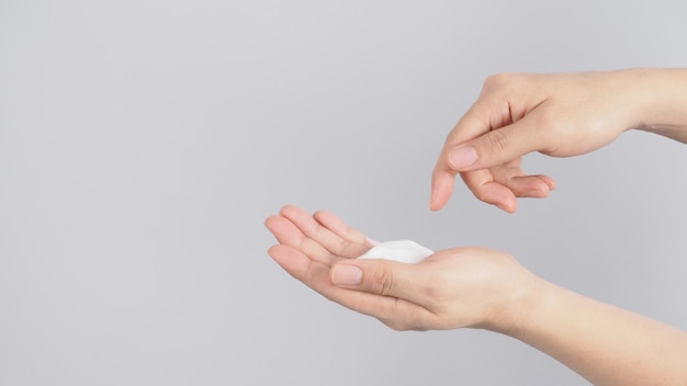 Geste de lavage des mains avec du savon moussant pour les mains sur fond blanc.