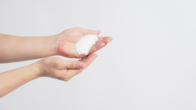 Geste de lavage des mains avec du savon moussant pour les mains sur fond blanc.