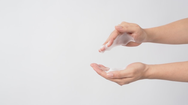 Geste de lavage des mains avec du savon moussant pour les mains sur fond blanc.