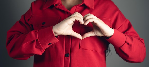 Geste de la main de femme en forme de coeur montrant l'amour