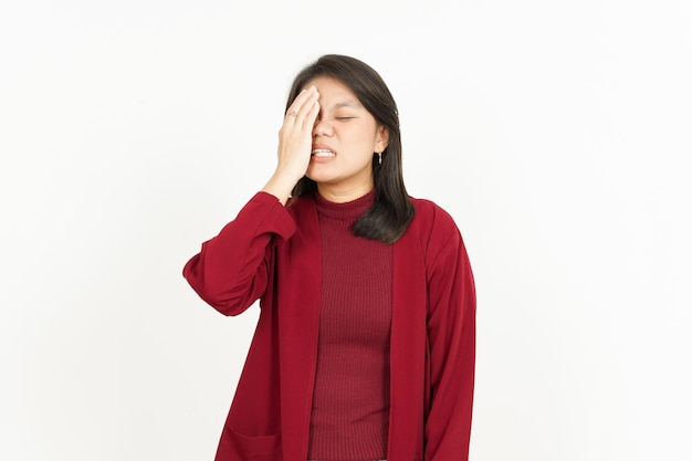 Geste de mal de tête de belle femme asiatique portant une chemise rouge isolé sur fond blanc