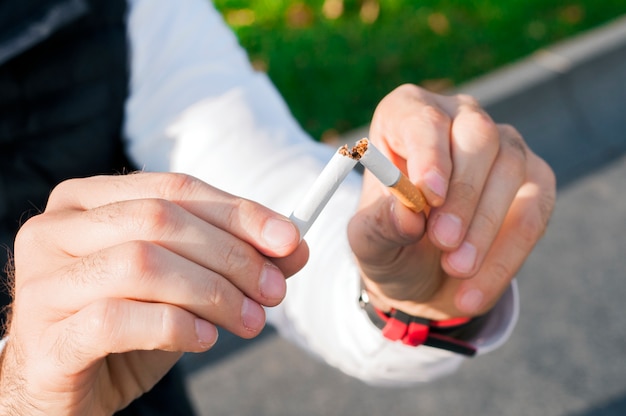 Photo geste pour cesser de fumer, anti-tabagisme, cigarette mâle à la main, non fumeur. l'homme a décidé d'arrêter de fumer.