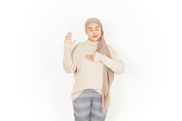 Geste de serment faire un serment de belle femme asiatique portant le hijab isolé sur fond blanc