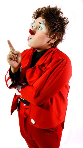 Gestes d'un clown mignon devant la caméra et avec un fond blanc