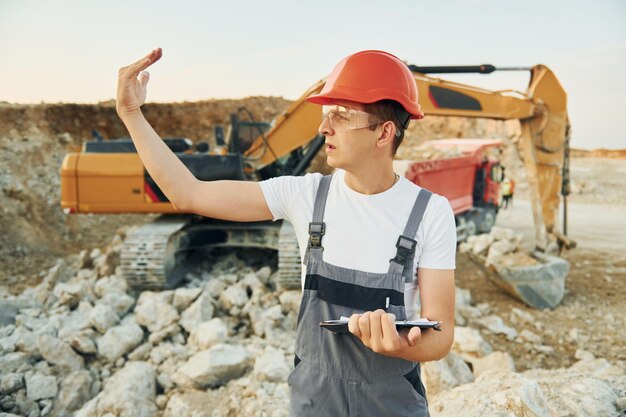 Gestion du projet Un travailleur en uniforme professionnel est sur le banc d'emprunt pendant la journée