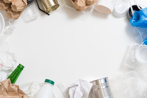 Gestion et tri des déchets. Plastique, papier, verre, déchets métalliques encadrant l'espace de copie ovale au centre.