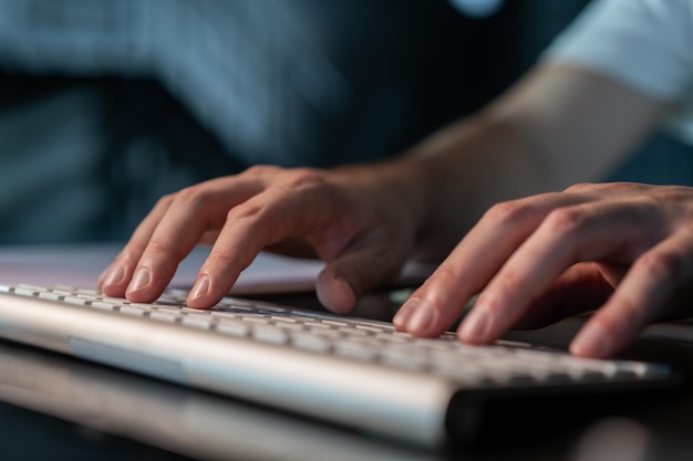 Gestionnaire de bureau mains mâles tapant sur le clavier de l'ordinateur gros plan Homme d'affaires travaillant sans visage deux mains sur le clavier sans fil Concept de travail de bureau