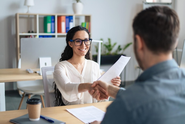Photo gestionnaire du personnel féminin souriant et demandeur d'emploi se serrant la main après un emploi réussi