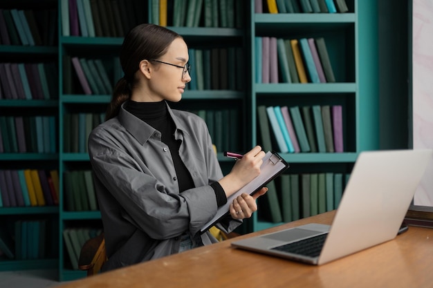 Le gestionnaire est une femme avec des lunettes travaillant dans un espace de coworking de bureau utilise un ordinateur portable fait un rapport d'entreprise sur un appel vidéo