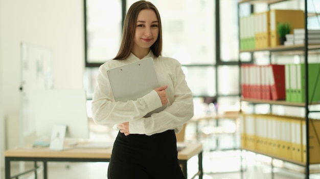 Gestionnaire de femme avec presse-papiers dans les mains en portrait de bureau