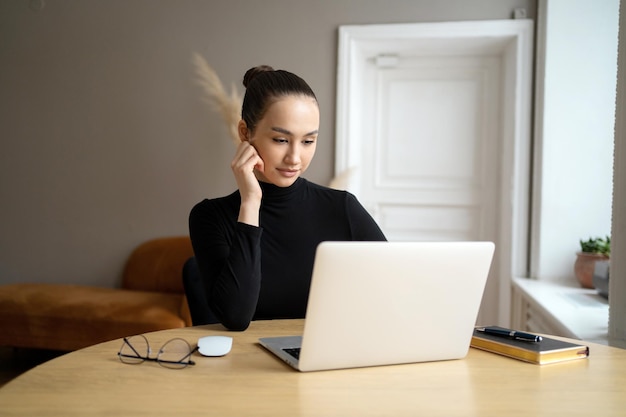 Gestionnaire indépendant surfer sur Internet Une femme travaillant dans un bureau utilise un ordinateur portable Écrit une lettre