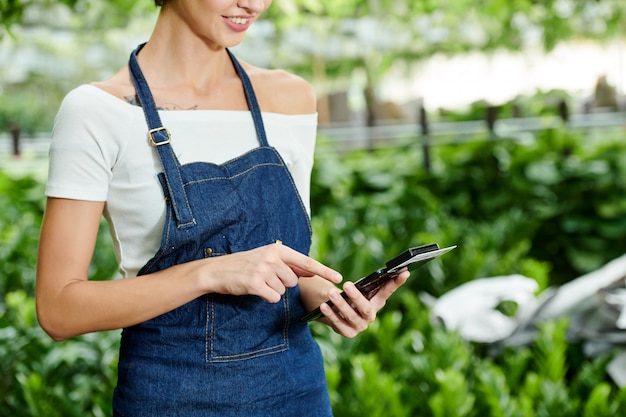 Gestionnaire de jardin de pépinière saisissant la somme d'achat