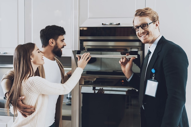 Le Gestionnaire Montre Une Cuisinière Intégrée à Des Clients En Couple.