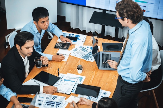 Gestionnaire de projet planifiant les horaires des tâches professionnelles dans la salle de réunion Logiciel de diagramme de Gantt affiché sur écran de télévision Gens d'affaires multi-ethniques et gestion de projet d'entreprise moderne Méticuleux