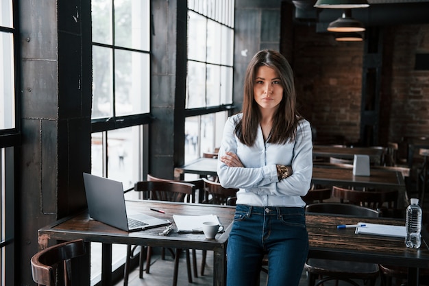 Gestionnaire sérieux. Une femme d'affaires en tenue officielle est à l'intérieur du café pendant la journée.