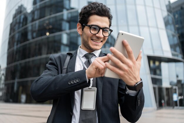 Le gestionnaire utilise une tablette pour écrire un message de communication à un collègue un homme avec des lunettes