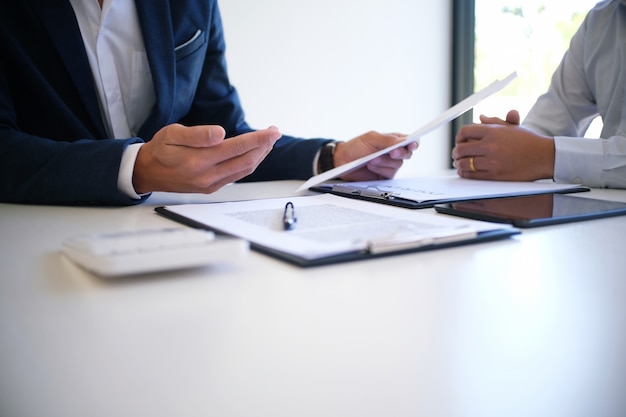 Photo gestionnaire des ventes donnant un document de formulaire de demande de conseil, en considérant une offre de prêt hypothécaire pour l'assurance automobile et immobilière.