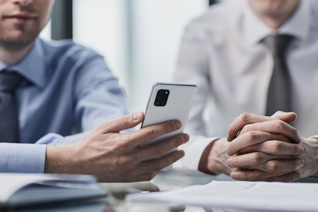 les gestionnaires lisent un message texte sur un téléphone portable au bureau