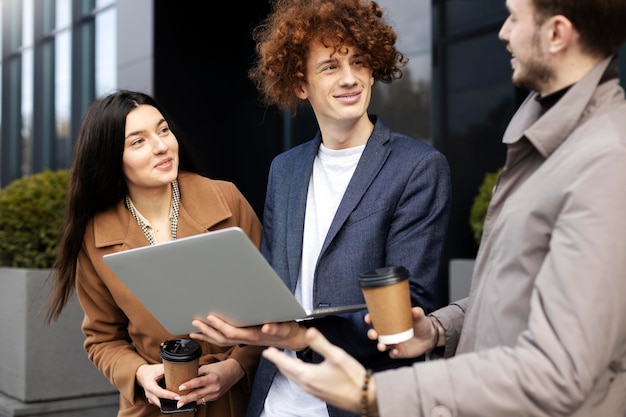 Les gestionnaires souriants communiquent à l'extérieur de Guy à l'aide d'achats en ligne pour ordinateur portable Concept d'entreprise prospère