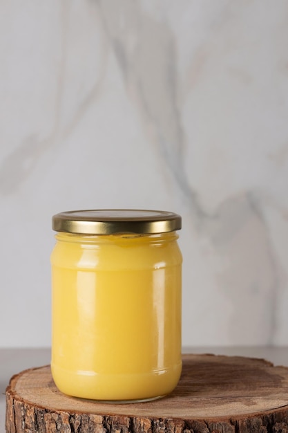 Ghee clarifié beurre desi dans un pot de verre avec du romarin sur fond de bois naturel