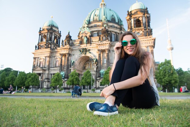 Photo gil s'asseyant devant la cathédrale de berlin au beau coucher du soleil