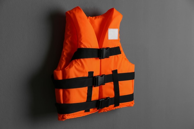 Photo gilet de sauvetage orange sur fond gris dispositif de flottaison personnel