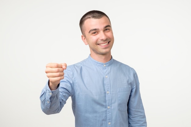 Gimme geture Young hispanic man doing fist bump on white studio shoot