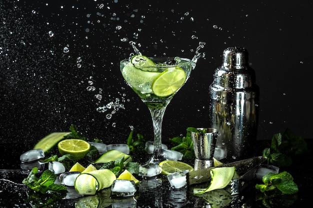 Gin de concombre et cocktail d'alcool de vodka Mocktail d'été infusé avec des agrumes frais et du concombre avec un mouvement de gel des éclaboussures de liquide dans un bocal en verre sur fond sombre