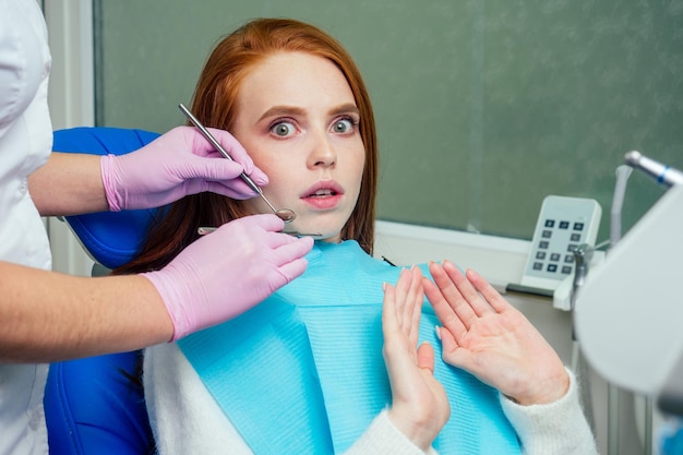 Le gingembre aux cheveux roux a souligné une patiente effrayée lors d'un examen dentaire de contrôle à la clinique