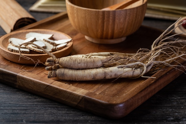 Le ginseng, le goji et le jujube sont dans l'assiette en bois