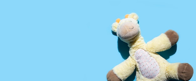 Photo girafe en peluche pour enfants sur fond bleu vue de dessus mise à plat bannière