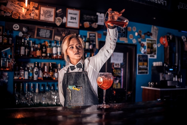 Girl barman crée un cocktail dans le portier