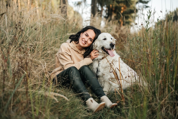 girl, étreindre, a, chien golden retriever, dans, les, champ