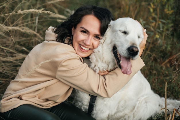 girl, étreindre, a, chien golden retriever, dans, les, champ