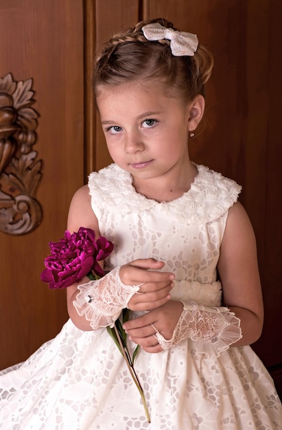 Girl holding bouquet de pivoines fraîches sur fond de bois