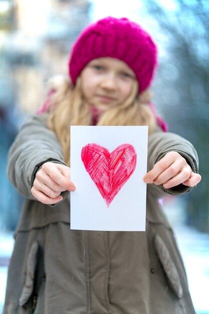 Girl holding dessin avec un coeur le jour de la Saint-Valentin