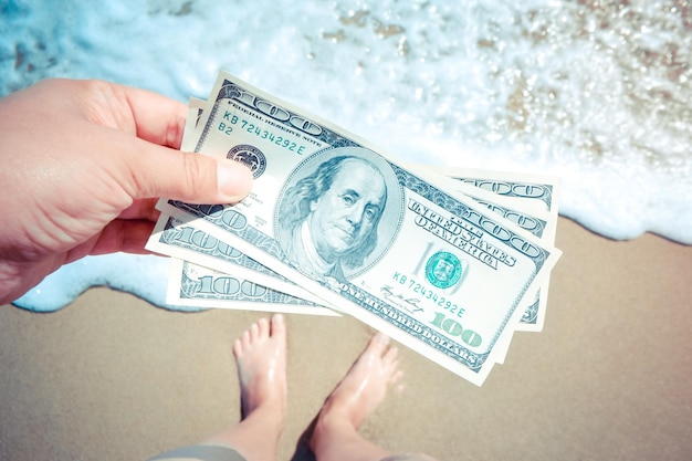 Girl holding money bill de 300 dollars sur fond de mer océan