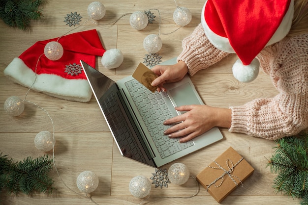 Girl shopping en ligne pour des cadeaux de Noël avec des décorations de Noël