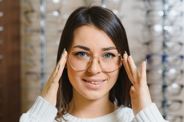 Girl Shopping pour les lunettes sur la saison de vente en magasin d'optique.