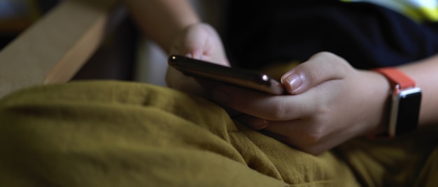 A, girl, tenue, smartphone, quoique, séance, jambes croisées, dans, salle de séjour